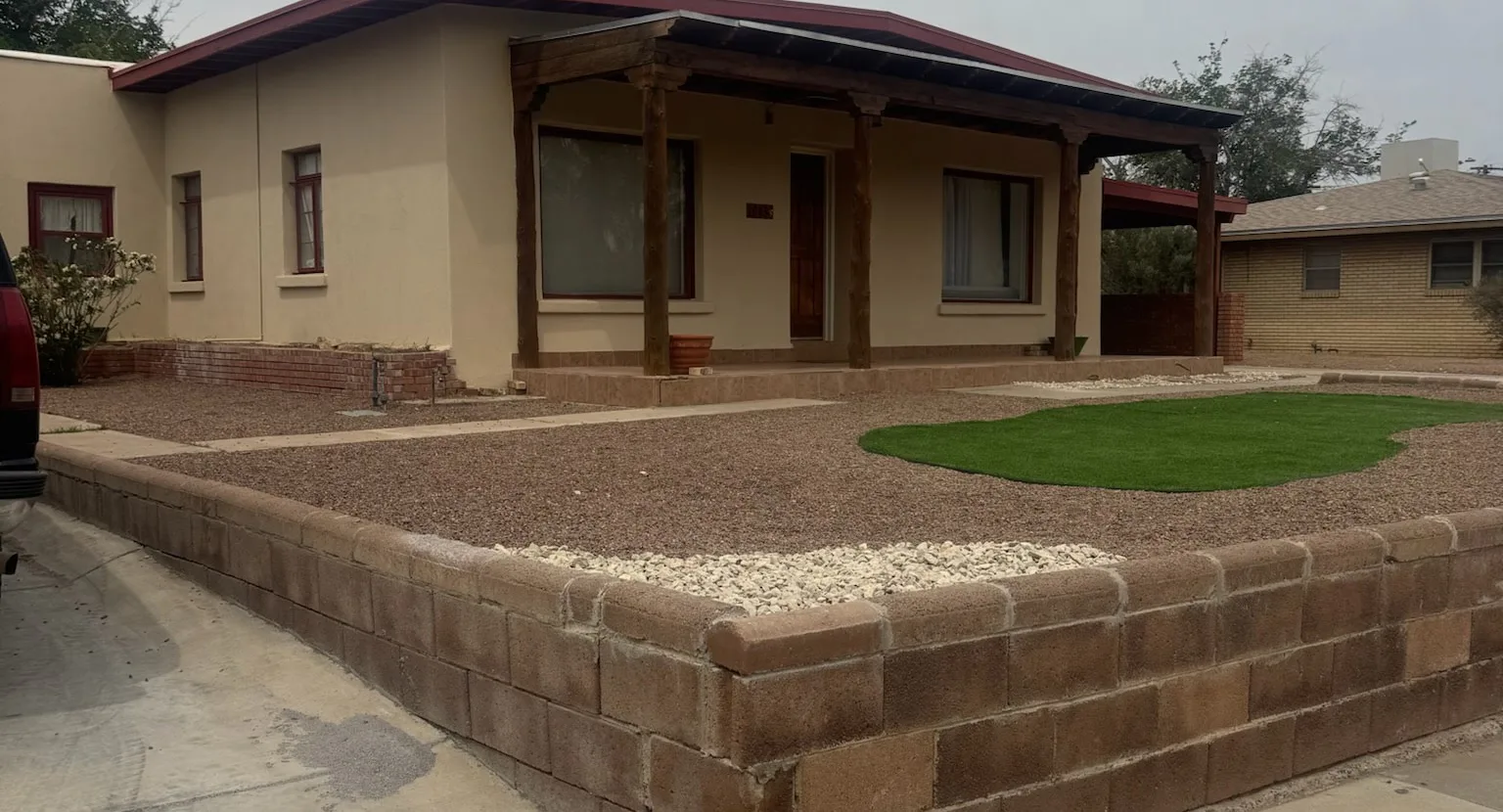 After: finished front-yard xeriscape with layered gravel, accent stones, and an artificial turf accent