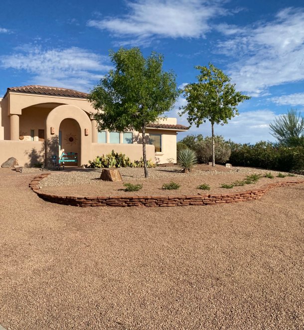 Custom stone border separating planting beds and gravel