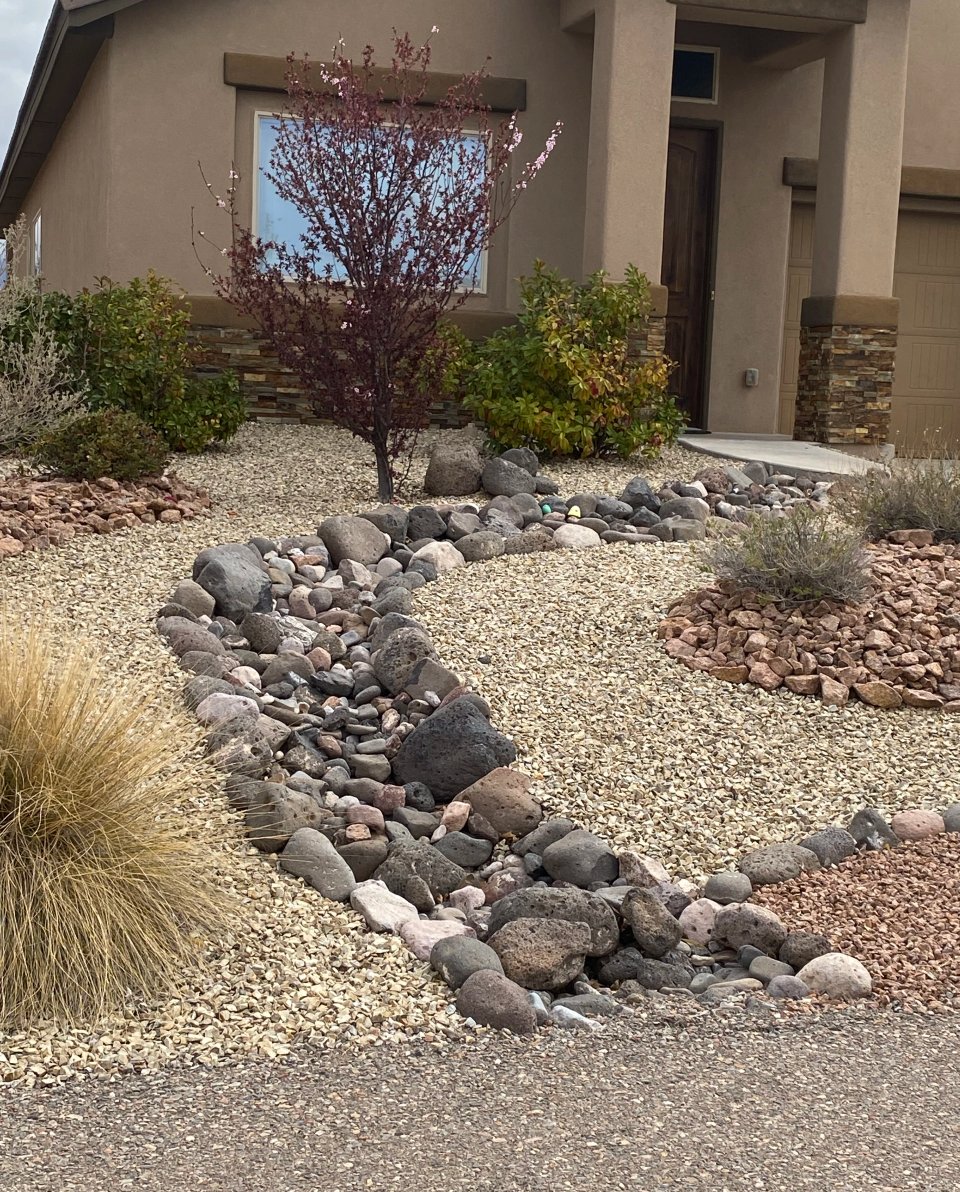 Front-yard stormwater channel and dry creek bed routing monsoon runoff away from a Las Cruces home by Brainard's Greenscapes